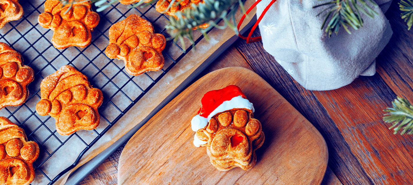 Gingerbread dog biscuits cool on a rack before being decorated.