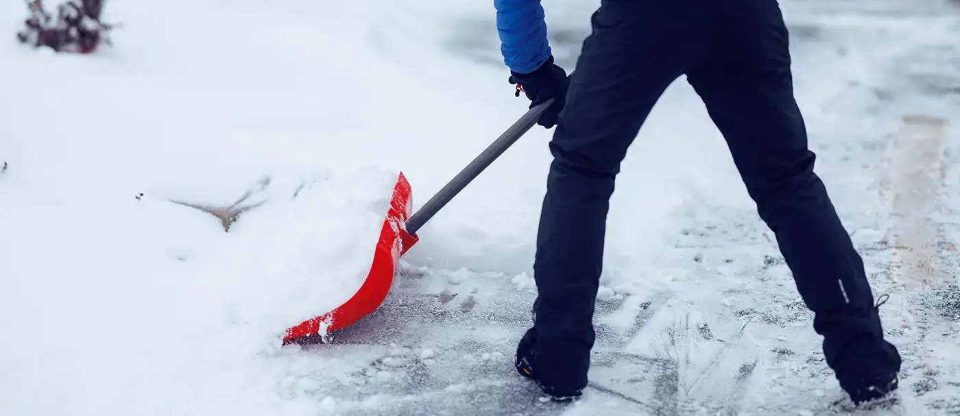 Un homme qui pelte après une tempête de neige en hiver au Canada.